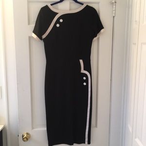 Vintage inspired short-sleeve black dress with white button details.